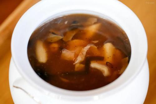 a cup of soup with the letter k in it at Lu Ming Beiyuan Xi'an Zhongdu Drum Tower City Wall Store in Xi'an