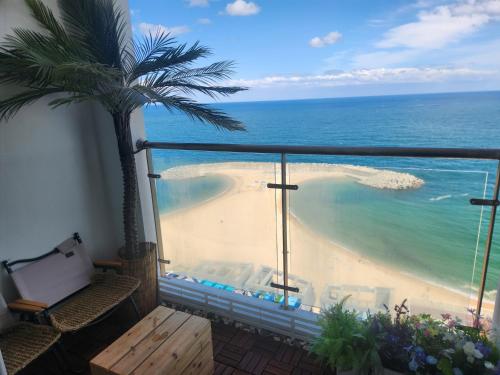 a balcony with a view of the ocean and a beach at 등대해수욕장 써밋베이 숙소#13 in Sajin