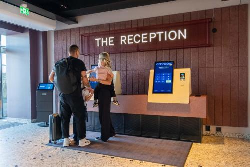 two people standing at a ticket counter at an airport at Citybox Stockholm in Stockholm