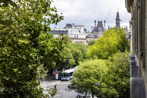 a city street with a bus on the road at Hôtel Korner Châtelet in Paris