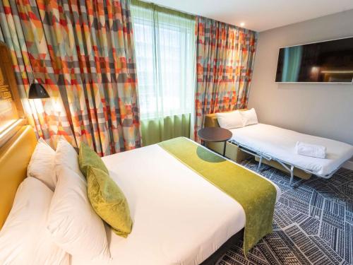 a hotel room with two beds and a tv at ibis Styles Leeds City Centre Arena in Leeds