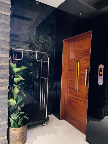 a bathroom with a walk in shower next to a wooden door at Lahore Continental Hotel in Lahore