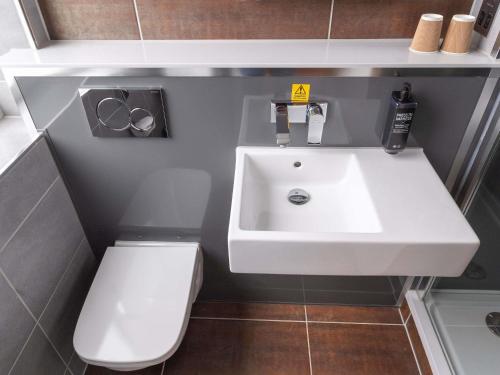 a bathroom with a white sink and a toilet at ibis Styles Leeds City Centre Arena in Leeds