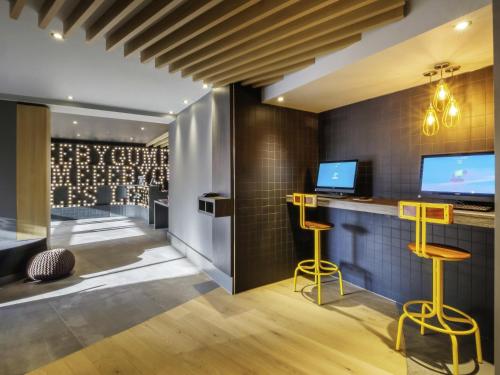a bar in a wine tasting room with yellow stools at ibis Styles Leeds City Centre Arena in Leeds