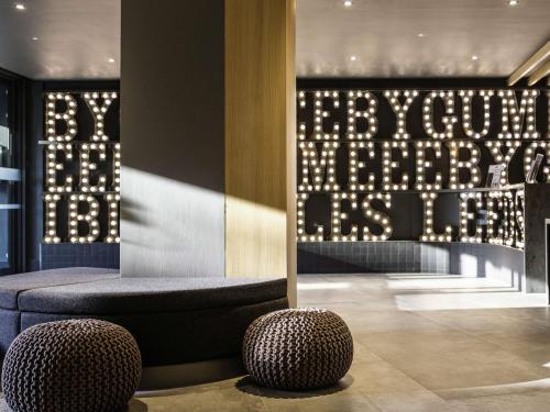 a lobby with a bench and a window with lights at ibis Styles Leeds City Centre Arena in Leeds