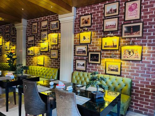 a restaurant with tables and chairs and a brick wall at Lahore Continental Hotel in Lahore