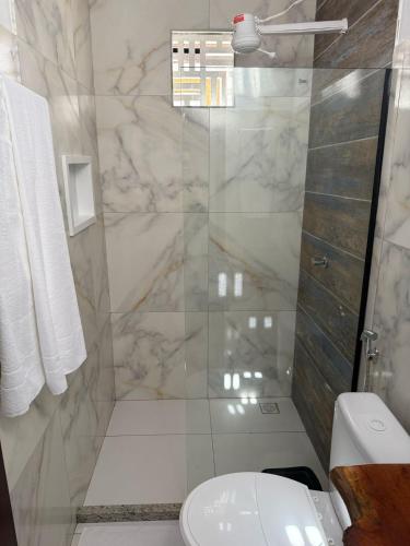 a bathroom with a toilet and a glass shower at Canto das Praieiras - Porto de Sauípe, Rio & Mar in Porto de Sauipe