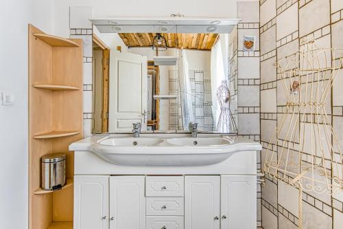 a bathroom with a white sink and a mirror at Maison de Vacances d'Amélie in Saint-Germain-dʼEsteuil