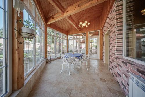 een afgeschermde veranda met een tafel en stoelen bij The Exquisite Residence in Zheleznitsa