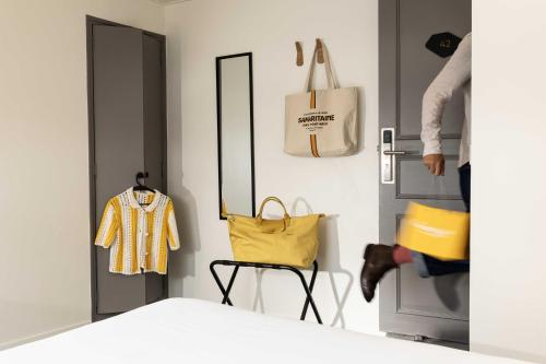a room with a yellow bag and a chair at Hôtel Korner Châtelet in Paris