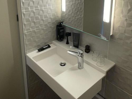a white sink in a bathroom with a mirror at Ibis Styles Toulouse Blagnac Aéroport in Blagnac