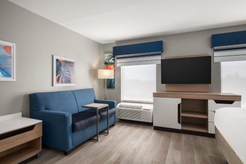 a small room with a blue chair and a television at Holiday Inn Express & Suites Destin - Miramar Beach by IHG in Destin