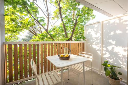 a white table and chairs on a balcony with trees at Babel Community Hôtel Lille - Villeneuve d'Ascq in Villeneuve d'Ascq