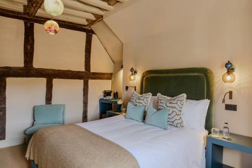 a bedroom with a large bed and a blue chair at House of George W Davies in Broadway