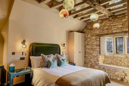 a bedroom with a large bed and a stone wall at House of George W Davies in Broadway