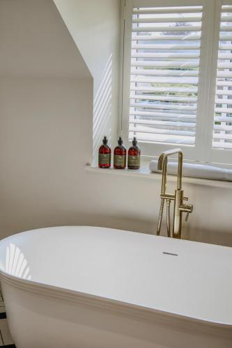 a white bath tub in a bathroom with a window at House of George W Davies in Broadway