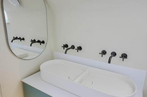 a bathroom with a white sink and a mirror at House of George W Davies in Broadway