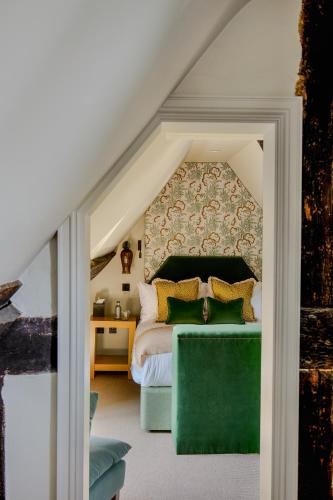 a bedroom with a bed and a green couch at House of George W Davies in Broadway