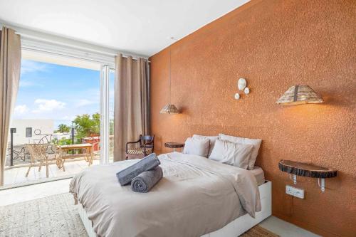 a bedroom with a large bed and a balcony at Lakaz Lagon - Entre Vue Mer & Montagne, Jacuzzi in La Gaulette