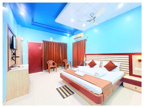 ein Schlafzimmer mit einem großen Bett und einem Fernseher in der Unterkunft HOTEL SWARNA VILLA Near Sea Beach & Jagannath Temple - Fully Air Condition with All Luxury Rooms With Attached-Balcony Free Wifi & Restaurant - Free Parking -Facilities# Boutique Services - A Top Rated Hotel In Puri in Puri