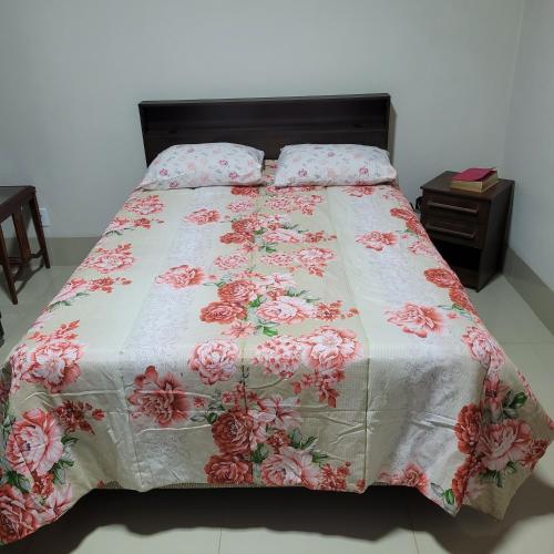1 cama con colcha floral y almohadas en Casa aconchegante, en Franca
