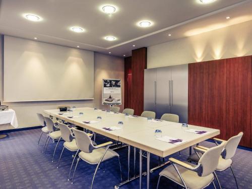 a conference room with a large table and chairs at Mercure Hotel München Airport Freising in Freising