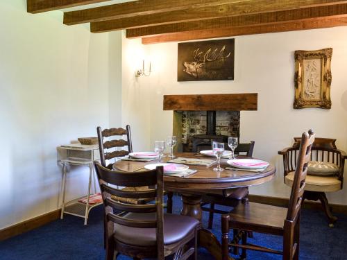 a dining room with a table and chairs and a fireplace at The Old Thatched Cottage in Tenterden