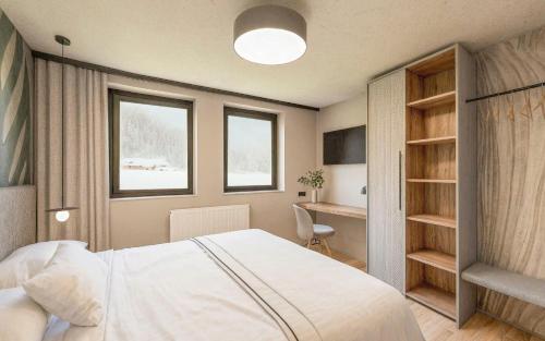a bedroom with a white bed and a desk at Carpe Solem Kaprun 4 star superior Hotel by ALPS RESORTS in Kaprun