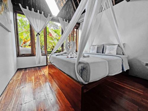 a bedroom with two beds with mosquito netting at Lagoona Beach Bungalows - Eco Bungalows Batukaras in Batukaras