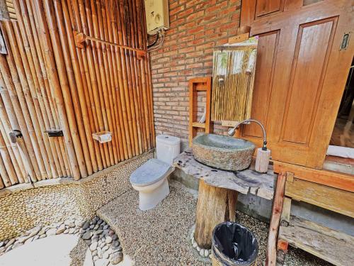 a bathroom with a sink and a toilet at Lagoona Beach Bungalows - Eco Bungalows Batukaras in Batukaras