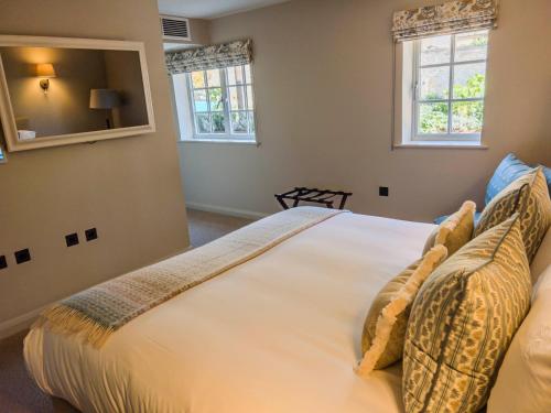 a bedroom with a large white bed with two windows at House of George W Davies in Broadway