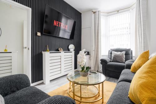 a living room with a couch and a table at Newly Renovated 4BR House with lots of amenities in Liverpool