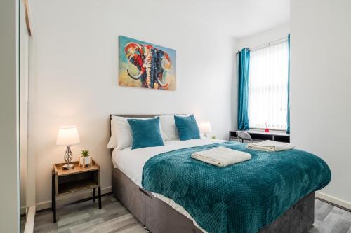 a bedroom with a bed with a blue blanket at Newly Renovated 4BR House with lots of amenities in Liverpool