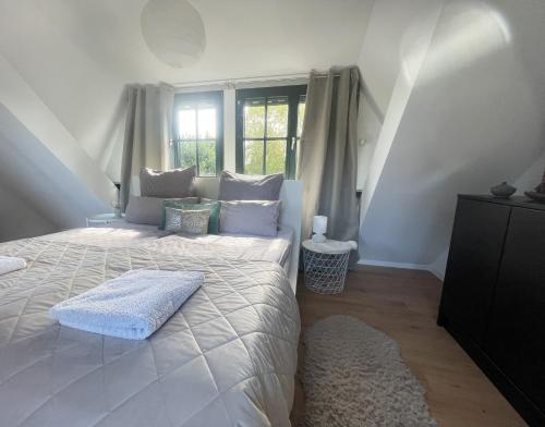 a bedroom with a large white bed with a window at CHARMANTE WOHNUNG mit Garten, gemütlich, ruhig, zentral in Neukirchen-Vluyn