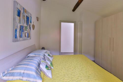 a bedroom with a yellow bed and a window at Donadelmar2 in Riomaggiore