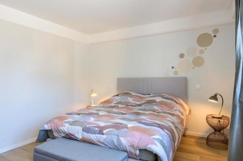 a bedroom with a bed and a table and lamps at Au Bretzel in Ostheim