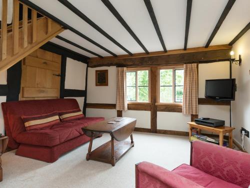 a living room with a red couch and a table at Parkers in Mathon
