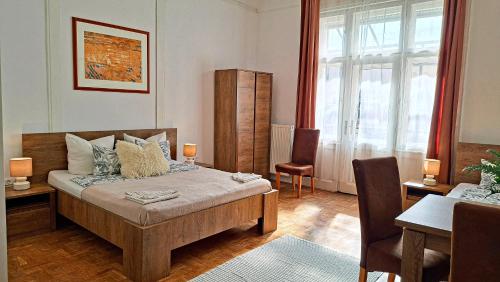 Un dormitorio con una cama y una mesa y sillas. en Black Sheep Budapest Smart Rooms, en Budapest
