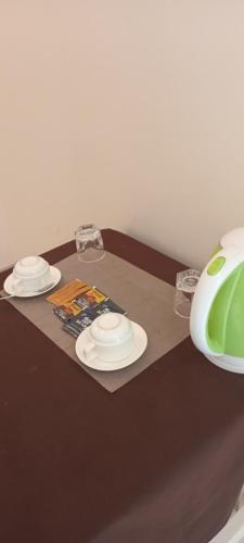 a table with two white plates and a green vase at The Var Zanzibar in Kendwa