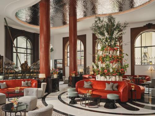 a lobby with red couches and a christmas tree at One Aldwych in London