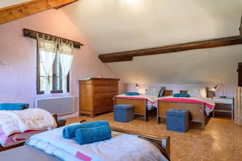 a attic room with three beds and a dresser at Chez Maurice in Saint-Maurice-sur-Moselle