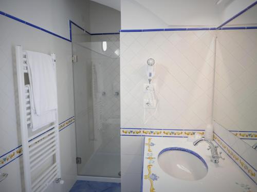 a bathroom with a sink and a shower at Hotel Vittoria in Positano