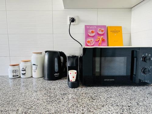 a kitchen counter with a microwave and coffee cups at Atlantica in Rabat