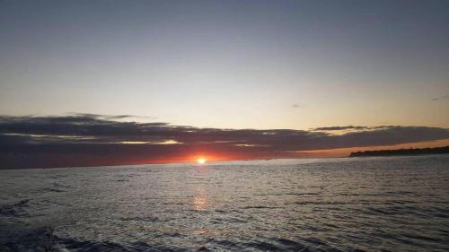 a sunset over a body of water with the sun setting at Tiapaa Village in Maupiti