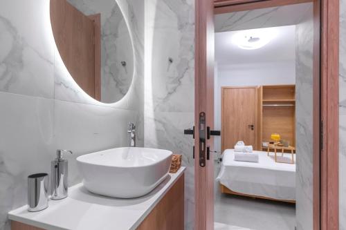 Baño blanco con lavabo y bañera en Callisto Elegant Apartment Near Acropolis, en Atenas