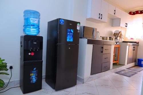 a kitchen with a water bottle on top of a refrigerator at ELDI Homes in Thika