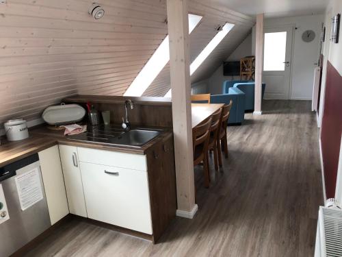 a kitchen with a sink and a table in a room at Schäferstübchen - Urlaub auf dem Bauernhof in Braunsberg