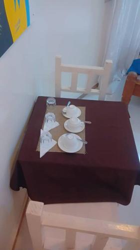a wooden table with plates and napkins on it at The Var Zanzibar in Kendwa