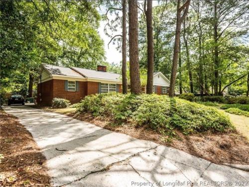 a house with a driveway in front of it at Central located large home on quiet wooded street in Lumberton