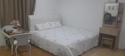 a bedroom with a bed and a table and a mirror at Raniah homestay in Kuching